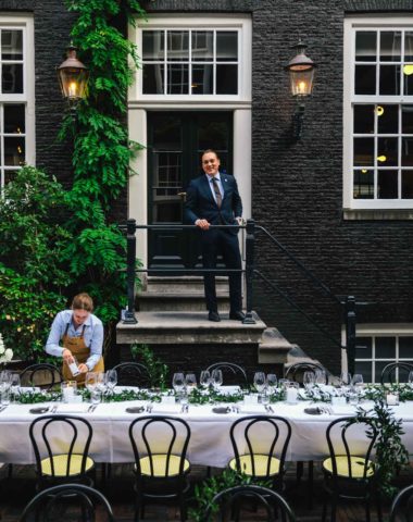 Setting a table ready for a wedding diner in the secluded garden of Bar Brasserie OCCO in luxury boutique hotel The Dylan Amsterdam.