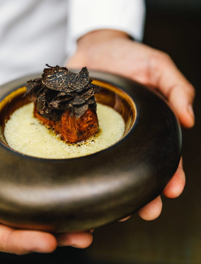 Chef at Restaurant Vinkeles presenting a truffle dish