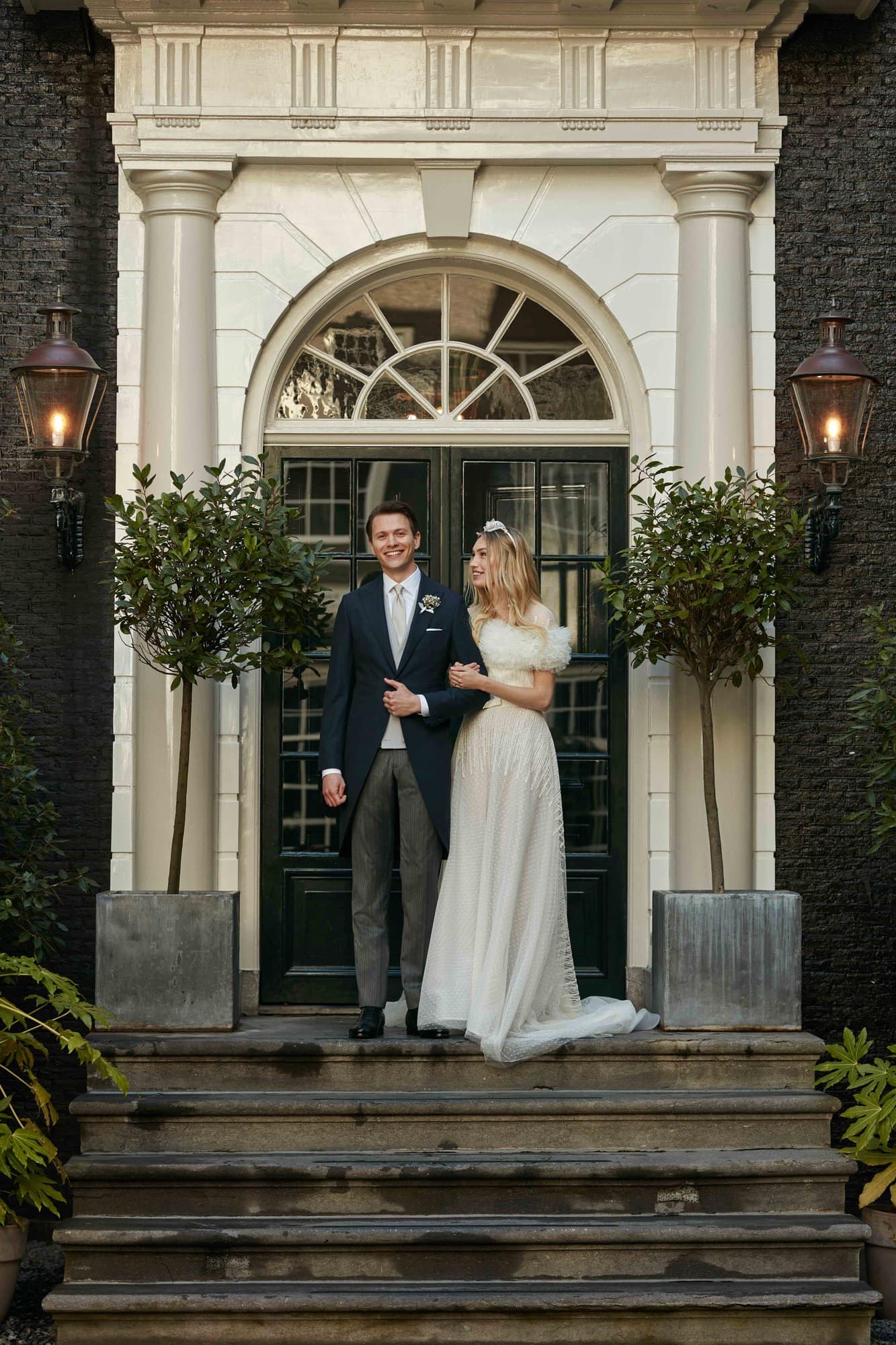 A married couple on the stairs of the secluded garden at luxury boutique hotel The Dylan Amsterdam.