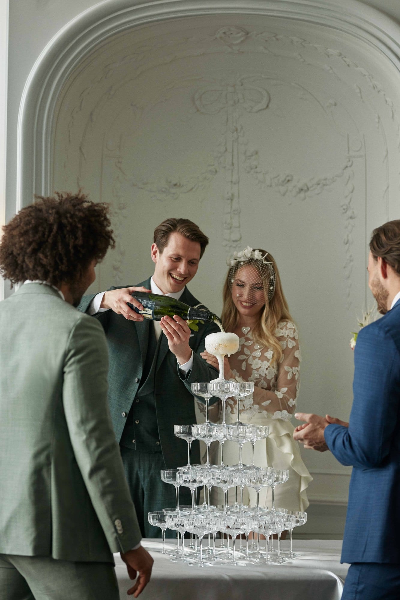 Pouring champagne in a campagne tower at a wedding in luxury boutique hotel The Dylan Amsterdam.