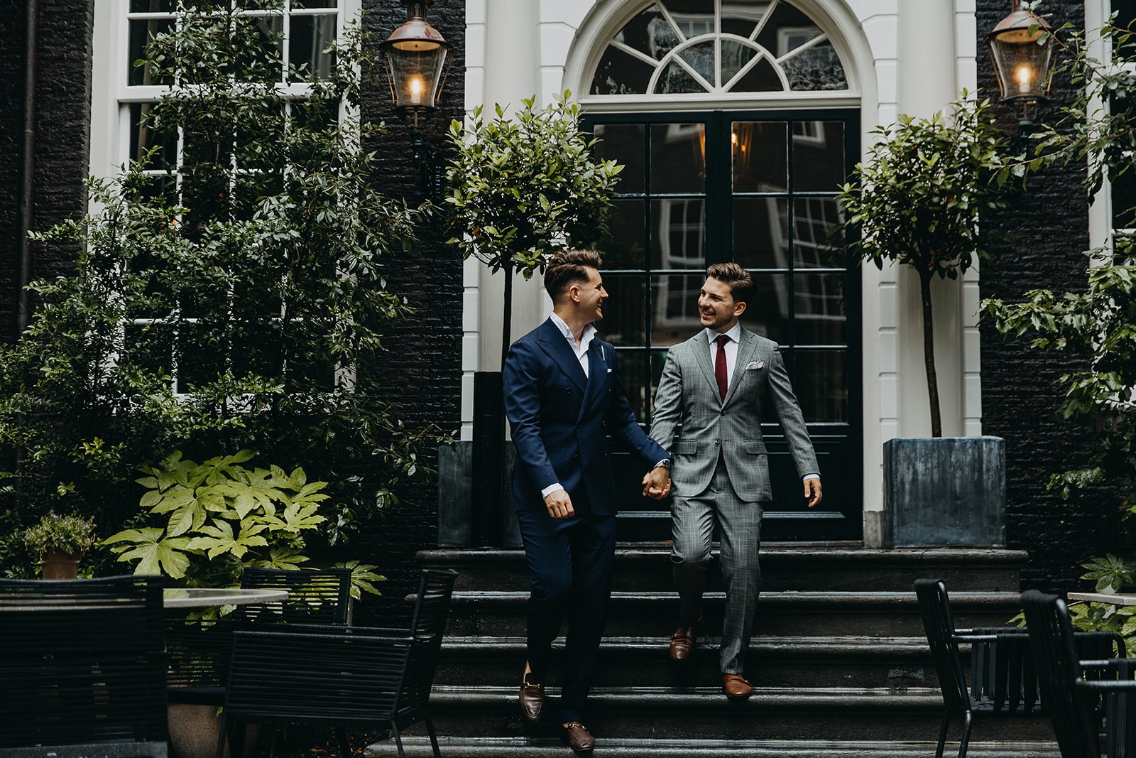 A married copple walking into the secluded garden of Bar Brasserie OCCO in luxury boutique hotel The Dylan Amsterdam.