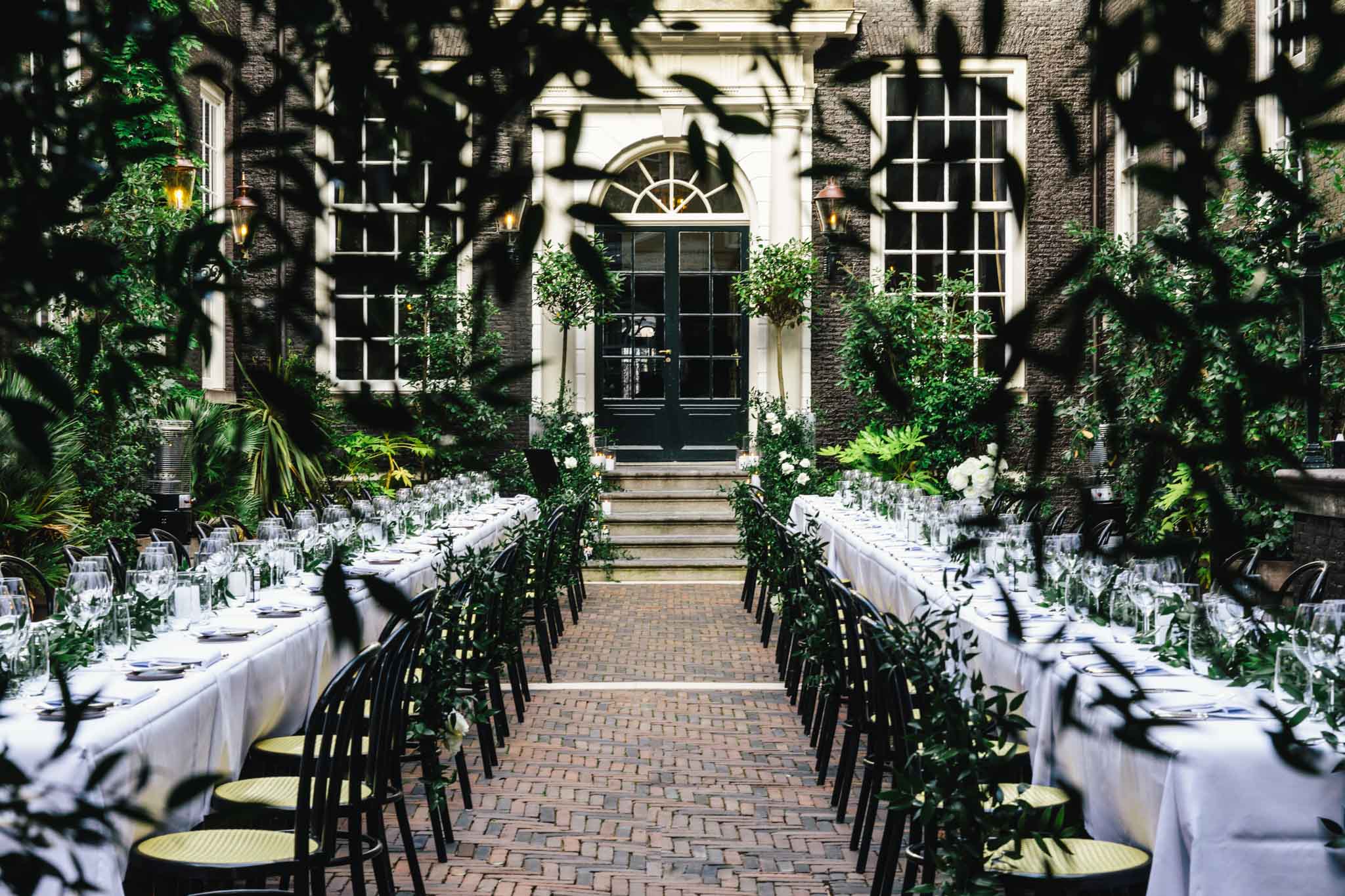 The secluded garden set for a dinner at a wedding at luxury boutique hotel The Dylan Amsterdam.