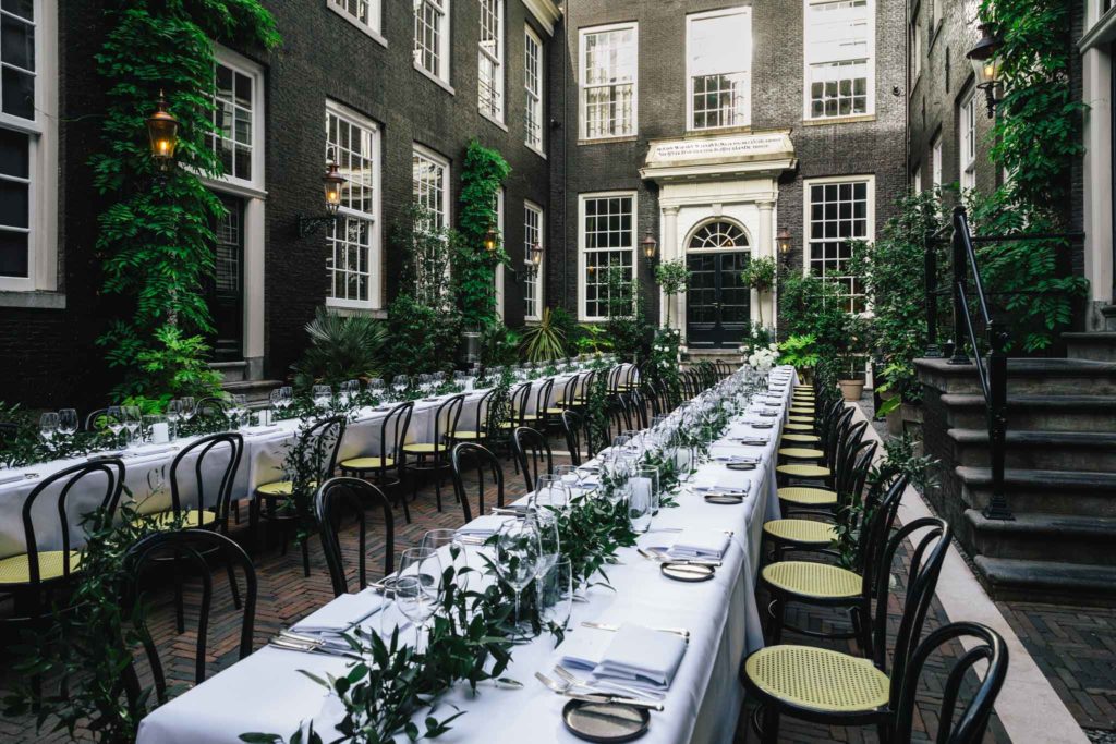 The secluded garden set for a dinner at a wedding at luxury boutique hotel The Dylan Amsterdam.