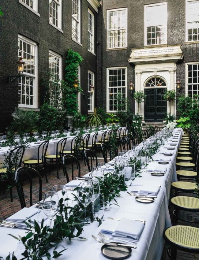 The secluded garden set for a dinner at a wedding at luxury boutique hotel The Dylan Amsterdam.