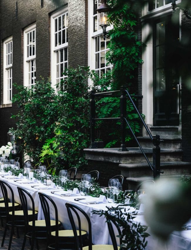 Table for a wedding dinner is set in the secluded garden of Bar Brasserie OCCO at luxury boutique hotel The Dylan Amsterdam.
