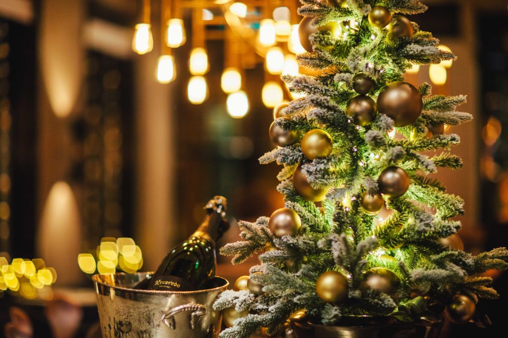 Festuive season at The Dylan Amsterdam. A christmas tree with know are golden christmas balls, celebrating Christmas with a bottle of wine.