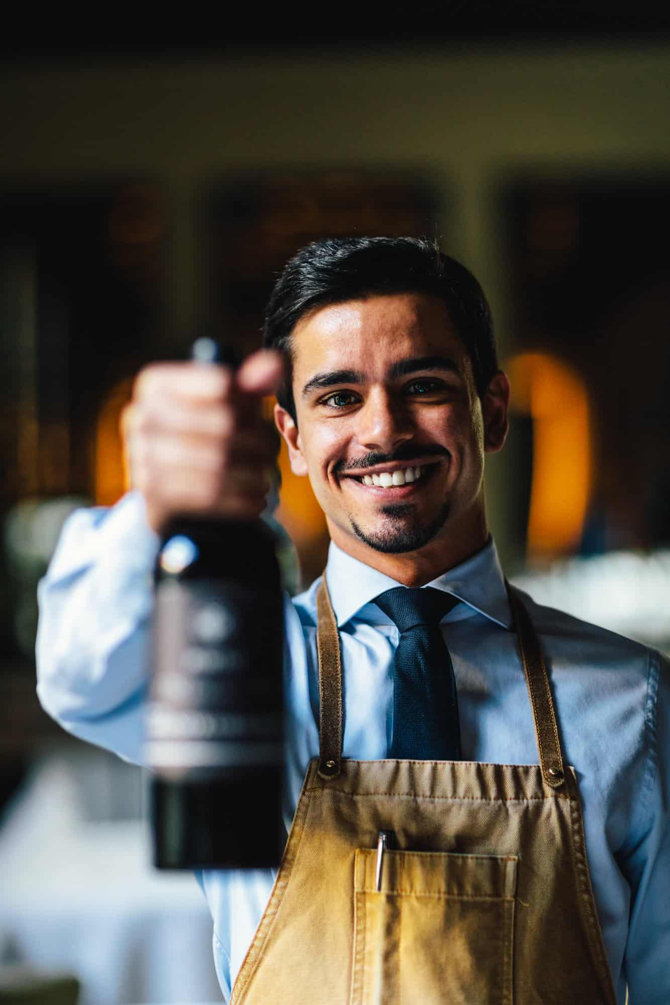 Miguel Caldihe holding a bottle of his favorite wine from the selection of Restaurant Vinkeles which is a Ramos Pinto Port wine from the 1982 vintage.