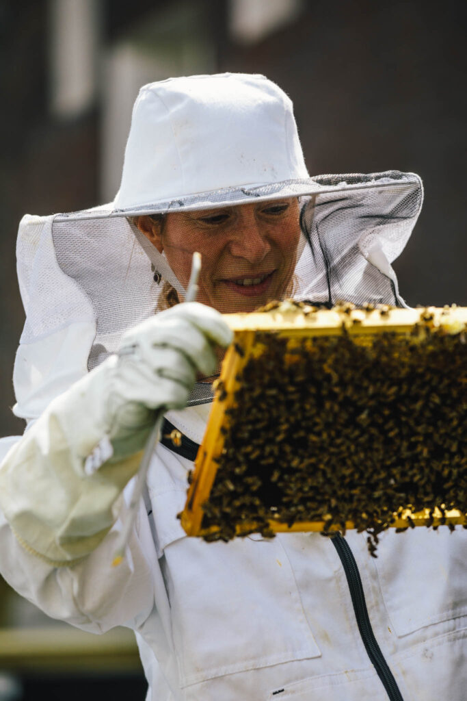 Anoushka de Graaf, beekeeper at The Dylan Amsterdam, holding a comb of honey that she just took out the beehive.