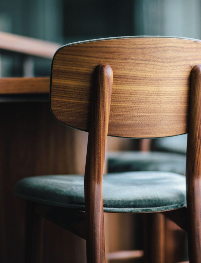 Wooden chair with a soft velvet seating at restaurant até in The Dylan Amsterdam, leading hotels of the world.
