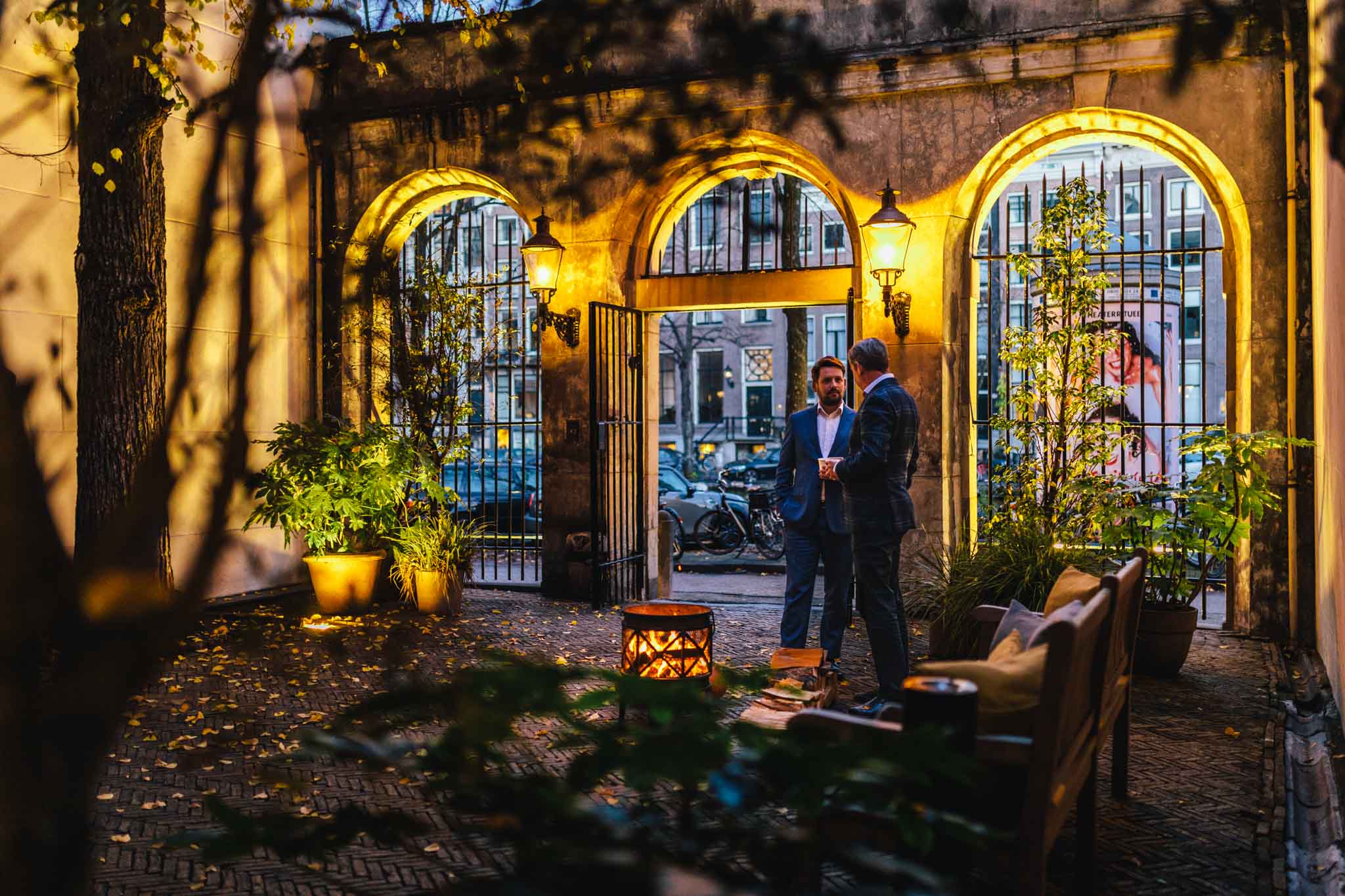 Robbert van Rijsbergen and René Bornmann standing in the front courtyard of The Dylan Amsterdam Leading Hotels of the World.