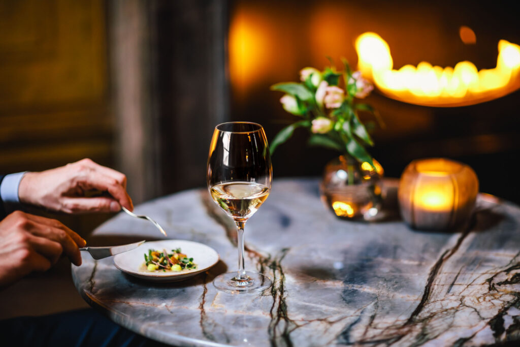 A glass of wine with a small dish during a High Wine at Bar Brasserie OCCO at The Dylan Amsterdam, part of The Leading Hotels of The World.