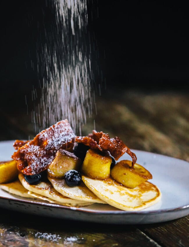 Plate with pancakes and bacon at Bar Brasserie OCCO at luxury boutique hotel The Dylan Amsterdam, part of The Leading Hotels of the World